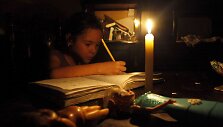Venesuela taupo elektros energiją, dėl to ji tiekiama ribotą laiką. Mergaitė ruo&scaron;ia namų darbus prie žvakių &scaron;viesos.