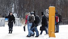 Norvegijos pasienio pareigūnė palydi migrantus