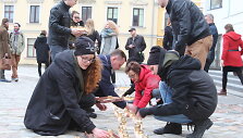 Protesto akcijos dalyviai Teatro aik&scaron;tėje i&scaron; gedulo žvakučių i&scaron;dėliojo kryžiaus ženklą.