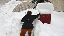Moteris bando įmesti lai&scaron;ką į pa&scaron;to dežutę.
