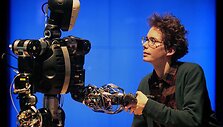 Moteris sveikinasi su robotu.
