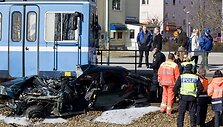 Gelbėtojai apžiūri sudaužytą automobilį.