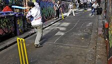 Policininkai ir indai žaidžia kriketą.