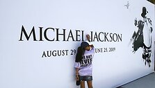 Mergaitė pirmoji pasira&scaron;o ant Michaelo Jacksono plakato.