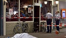 Olandų policija nusikaltimo vietoje greta kavinės.