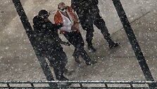 Policininkai i&scaron;veda įtariamąjį i&scaron; banko pastato.