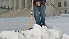 Darbininkas valo sniegą prie JAV Auk&scaron;čiausiojo teismo rūmų.