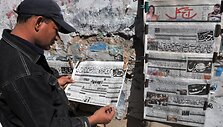 Pakistanietis skaito laikra&scaron;tį urdu kalba, kuriame prane&scaron;ama apie Abdulo Ghani Baradaro suėmimą.