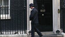 Didžiosios Britanijos premjero rezidenciją saugantis policininkas stebi miegantį katiną Larry.