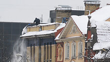 Du vyrai nuo stogo kasa sniegą
