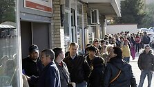 Bedarbiai ispanai stovi eilėje prie įėjimo į Darbo centrą.