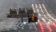 Darbininkai mėgina nuvalyti sniegą nuo lėktuvų kilimo tako Edinburgo oro uoste