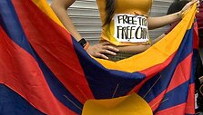 Pirmakursė universiteto studentė  Christina Chan Hau-man laiko Tibeto vėliavą prie&scaron; Olimpines jojimo varžybas Honkonge.