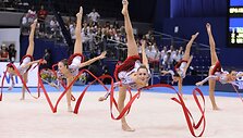 Meninės gimnastikos pasaulio čempionatas. Su raudonais kaspinais ir virvėmis pasirodo temperamentingosios ispanės. 