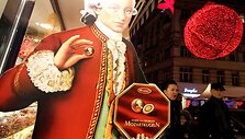 Kalėdiniai Vienos senamiesčio žiburiai ir W.A.Mozarto muliažas, siūlantis praeiviams paragauti saldainių.