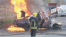 Ugniagesiai gesina automobilį.
