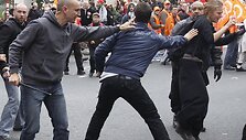 Civiliais rūbais vilkintis policininkas (kairėje) tramdo demonstrantą.