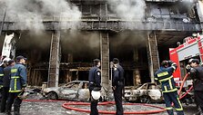 Gaisrininkai gesina padegtą parduotuvę Atėnuose.
