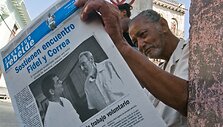 Žmogus Havanoje skaito laikra&scaron;tį su F.Castro nuotrauka