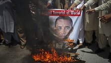 Musulmonų aktyvistai, smerkiantys &bdquo;al Qaeda&ldquo; lyderio Osamos bin Ladeno nužudymą, degina plakatą su JAV prezidento Baracko Obamos atvaizdu.