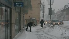 Parduotuvių darbuotojai ryte kasė praėjimus užgriuvusį sniegą. 