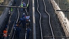 Darbuotojai taiso per žemės drebėjimą sugadintą geležinkelį.