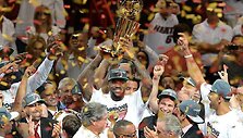 LeBronas Jamesas su NBA trofėjumi rankose
