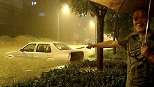 Vairuotojas rodo į savo apsemtą automobilį.