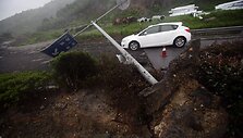 Automobilis važiuoja &scaron;alia nuvirtusio kelio ženklo.