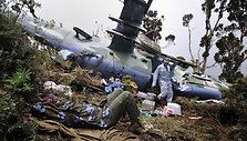 Sužeistas pilotas guli &scaron;alia sudužusio sraigtasparnio.