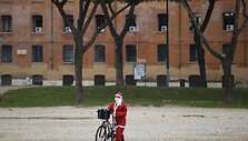 Kalėdų senelio kostiumu apsirengęs dviratininkas