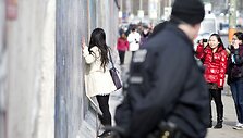 Merginos fotografuojasi &scaron;alia Berlyno sienos