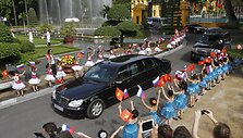 Mergaitės su Rusijos ir Vietnamo vėliavomis mojuoja atvykstančiam Vladimirui Putinui