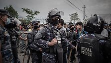 Katmandu policija prižiūri autobusų laukiančias minias žmonių.