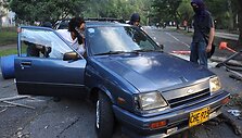 Studentai automobiliu užstato kelią vedantį į universitetą. 