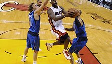 LeBronas Jamesas veržiasi pro Dirką Nowitzkį (kairėje) ir Tysoną Chandlerį