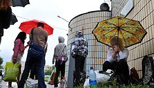 Prie kalėjimo Minske žmonės laukia kada galės perduoti proteste sulaikytiems artimiesiems atne&scaron;tus krep&scaron;ius su maistu.