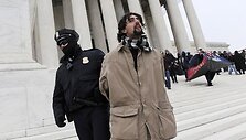JAV policininkas sulaiko demonstrantą, kuris prie JAV Auk&scaron;čiausiojo teismo dalyvavo penktadienio akcijoje &bdquo;užimk teismus&ldquo;