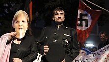 People role playing as Adolf Hitler (C) and German Chancellor Angela Merkel take part in a protest outside the German embassy in Athens October 6, 2011.