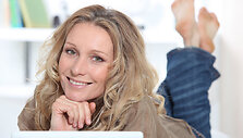 Smiling happy woman using a laptop