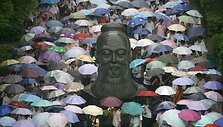 Studentai renkasi į egzaminų vietą eidami pro Konfucijaus skulptūrą