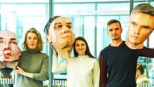 Studentai su savo sukurtomis kaukėmis-galvomis