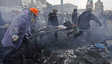 Anti-government protesters carry an injured man on a stretcher after clashes with riot police in the Independence Square in Kiev February 20, 2014. Ukrainian protesters hurling petrol bombs and paving stones drove riot police from the central square in Kiev on Thursday despite a "truce" which embatt