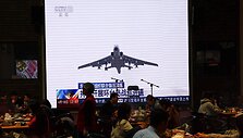 Klientai vakarieniauja &scaron;alia didžiulio ekrano / TINGSHU WANG / REUTERS