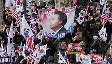 Yoon Suk-yeolo rėmėjai i&scaron;kėlę plakatą su jo atvaizdu / Ahn Young-joon / AP
