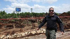 Izraelio policininkai tiria smūgio kraterį po husių raketos smūgio Ben Guriono oro uostui / Nir Elias / REUTERS