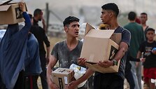 Palestiniečiai atsiima davinius Gazos Ruožo pagalbos skirstymo punkte / EYAD BABA / AFP