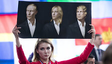 Rusijos žurnalistė su plakatu, kuriame &ndash; V.Putino, M.Le Pen ir D.Trumpo portretai