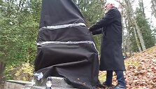 Kazimieras Juraitis plė&scaron;ia juodą audeklą nuo sovietinės skulptūros Antakalnio kapinėse