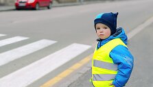 Vaikas vilki liemene su &scaron;viesą atspindinčiomis juostomis